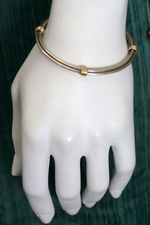 Elegant unisex bangle by silversmith Leonore Doskow of sterling with 18K gold wrapped terminals.<br />
Excellent condition<br />
2.5