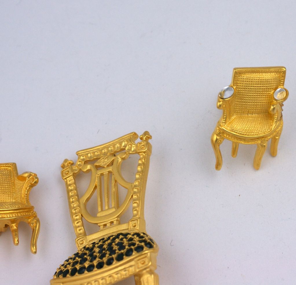 Playful iconic brooch and earring set by Karl Lagerfeld.Jet and crystal stones in matte gold settings. French lyre back chair with 