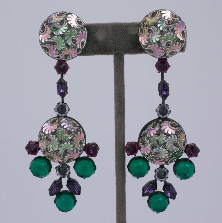 Unusual earrings by Schreiner NY. Iridescent molded glass is highlighted  with openbacked crystals in amythest, emerald and fuschia to mirror the sheen of the large stones. The japanned metal showcases the unusual colors in these earrings. 1960s