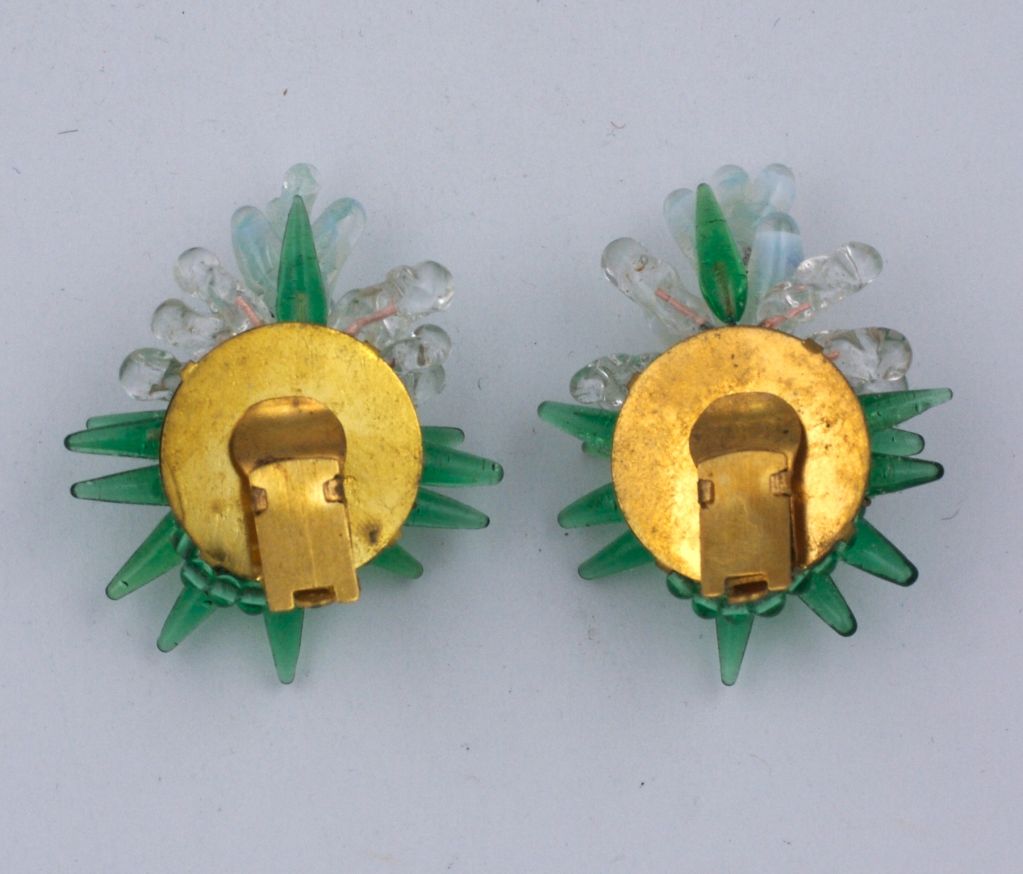 Poured glass earrings by Rousillet, Paris. Made of finely detailed glass stamen pegged into a gilt base.  Emerald, crystal and milky seafoam colorations. 1940s Paris.
Clip back fittings. 1.5
