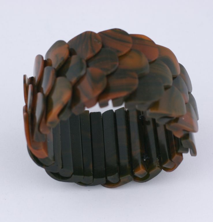 Unusual french bakelite stretch bracelet which is composed of end of day bakelite panels in deep green and butterscotch. The repetition of the links forms the fish scale effect. Excellent condition. 1940's France.