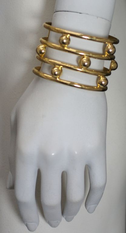 Deco style cuff by Nettie Rosenstein in gilt sterling. High style bar and dot motifs. 1940s.<br />
Excellent condition<br />
1.75