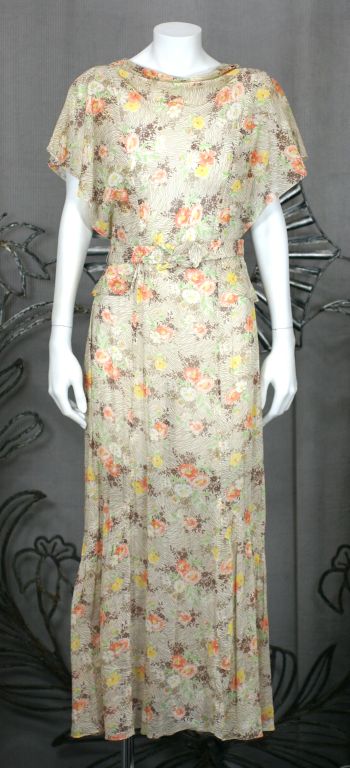 Charming one piece printed cotton voile day dress with faux peplum and self belt. Draped neckline and trapunto stitched origami belt. Soft cheese-clothy semi sheer weave and watercolor floral print. Nice side ruffles on hem of dress add fullness.<br