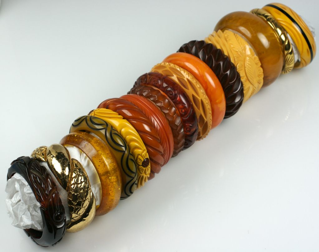 Wonderful selection of Bakelite and Lucite bangles from the 1930s-1940s American.<br />
<br />
From Bottom of Picture:<br />
A)Root Beer Bakelite deeply carved leaves (7/8") $450<br />
B) Gilt metal clad twist bakelite bracelet,1"(wear on