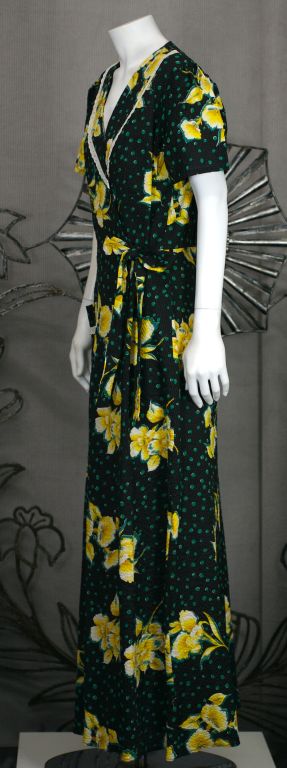 Charming wrap dress from the 1930s in graphic floral cotton seersucker with lace trim. Black with teal green dots and yellow tropical blooms.<br />
Excellent condition. Adjustable waist with self ties.<br />
<br />
<br />
SIZE 16 VINTAGE, 12 NEW