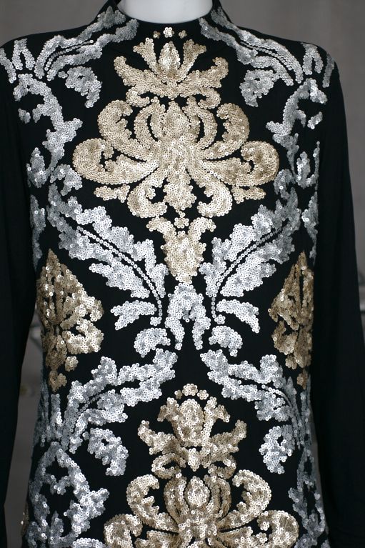 Attractive black matte jersey top with gold and silver matte sequins in heraldic patterns. Back zip entry.<br />
Label: Suzana Monacella <br />
Excellent condition.