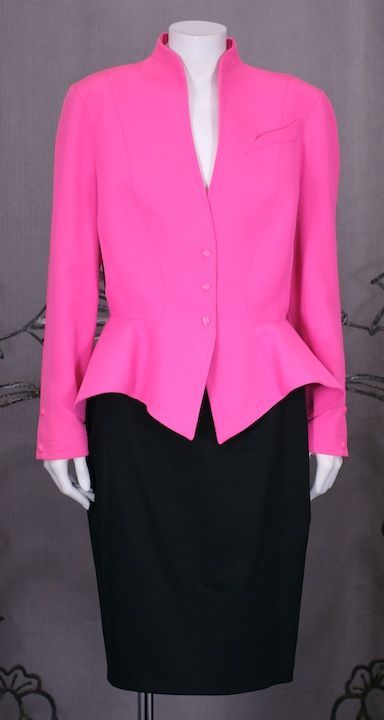 Hot pink wool gabardine suit by Thierry Mugler. Fiited waist with gently sloped peplum with pink snap closures at waist and wrist. Black gabardine slim skirt.

Jacket Waist 29