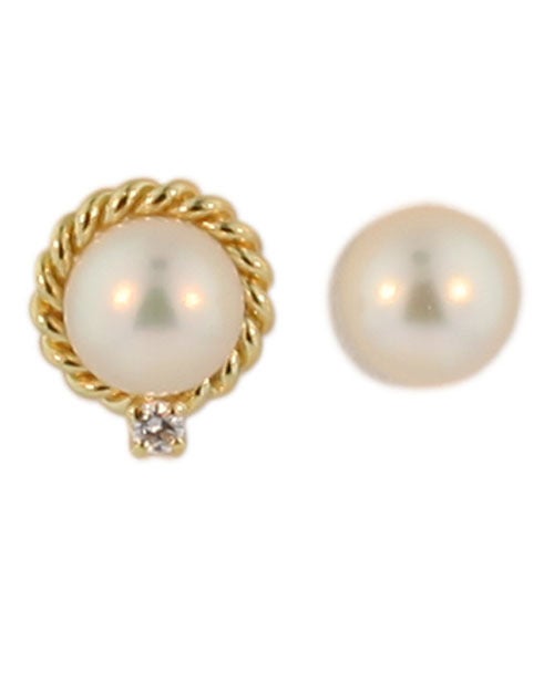 A charming pair of Mikimoto diamond and pearl earrings in a removable jacket, set in 18 kt gold with a .05 diamond on each jacket. They are stamped 18 kt and have the Mikimoto signature 