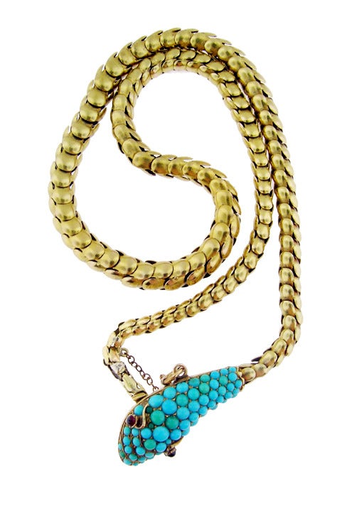 A hand made Victorian snake necklace set with cabochon turquoise and ruby eyes. The chain articulates beautifully and the workmanship is fine. The necklace tests positive for at least 14 KT gold and it is probably slightly higher. This piece is in