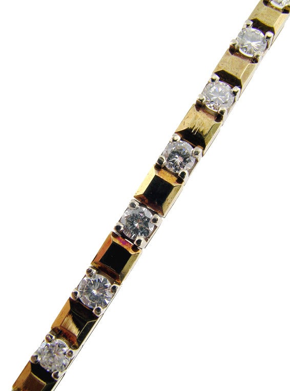 This bracelet is set in 14 KT yellow gold. It is set with 3.90 cts of round brilliant cut diamonds. The alternating diamonds and gold plaque create a designer look to this piece. It is in excellent condition and measures 7 inches.