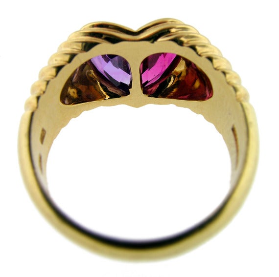 A classic Bvlgari heart ring in 18KT yellow gold featuring a tourmaline and an amethyst. Measures size 6.5