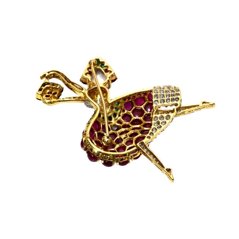 A marvelous ballerina brooch, articulately crafted with burmese ruby (no heat), a large rose cut diamond, brilliant-cut diamonds, and emerald in 18kt yellow gold.