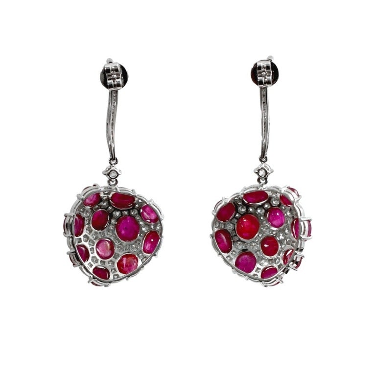 A pair of oval Burmese No Heat Ruby Cabochon Earrings with brilliant-cut diamonds set in 18kt White Gold. Accompanies a GIA Report indicating Burma (Myanmar), No Heat. Cabochons measure from 6.55 x 5.80 x 3.80 mm to 4.70 x 4.55 x 2.80 mm, Length of