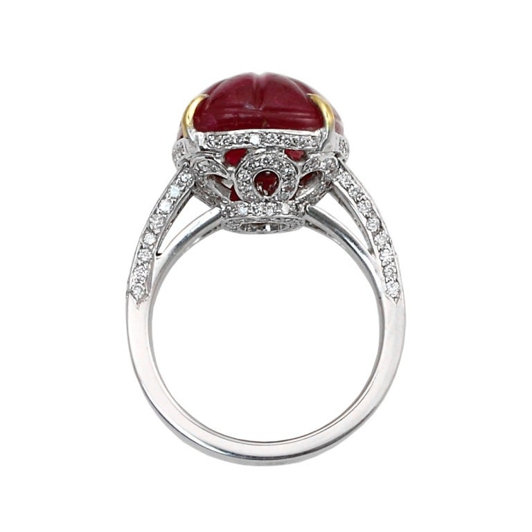 A stunning burmese ruby carving, weighing approximately fifteen carats accented with diamonds. Set in 18kt yellow gold and platinum. Ring Size 5 1/2 US.