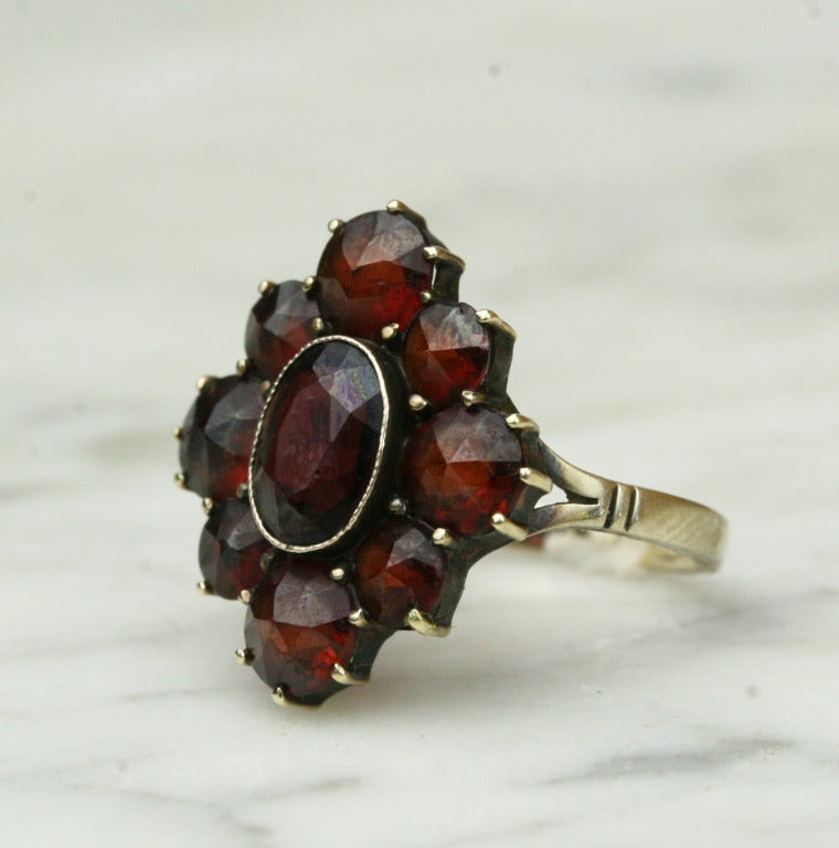 - 10k yellow gold, 9 rose- and oval brilliant-cut Bohemian garnets
- Made in Germany

A striking Bohemian garnet cluster ring, unusual for its wondrous size and use of fine 10k gold. The vast majority of these charming old garnet pieces are set