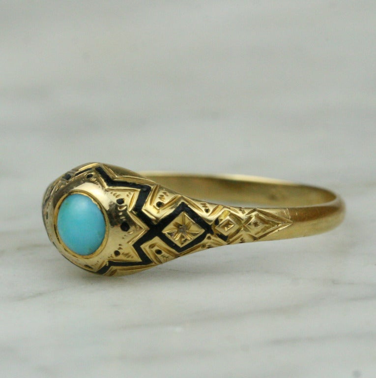 - 18-20k yellow gold, turquoise, enamel
- Made in France

A striking and unusual piece, this 18 karat gold dome ring features a bezel-set turquoise and elegant black enamel inlaid in an engraved band. Pin dots and a central star frame the center
