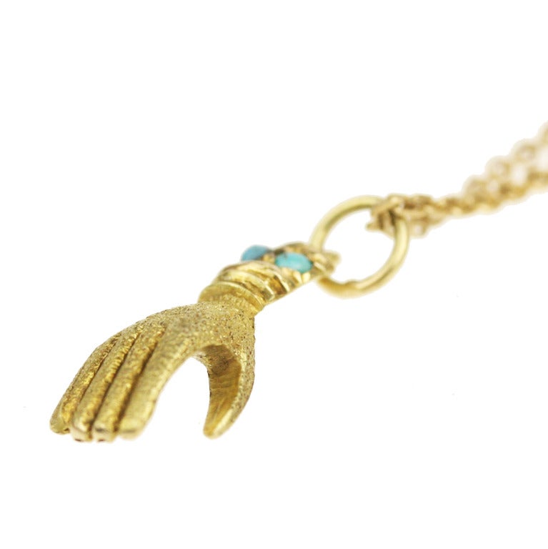- Carved Victorian Hand Pendant and Fine Gold Chain Necklace
- c. 1860-1890
- 14k gold, Persian turquoise

A lovely Victorian hand charm, elegantly crafted with a textured hand, engraved wrist, and Persian turquoise accents. Paired with an