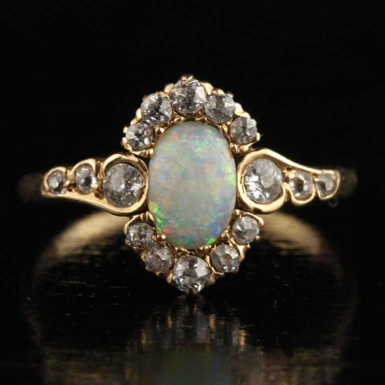 - Antique Opal and Diamond Halo Ring
- c. 1890-1910
- 14k yellow gold, approximately .41 carats old mine cut diamonds, opal

An absolutely exquisite find, this lovely art nouveau ring features a brilliant opal surrounded by 16 beautifully