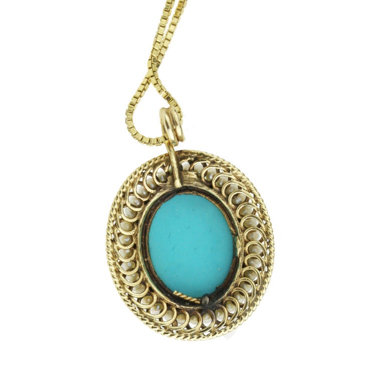 - Egyptian Revival Turquoise and Pearl Pendant Necklace
- c. 1950
- 14k yellow gold, seed pearls, turquoise
- Gold-plated sterling silver chain included

A lovely and intricate piece, this pendant features a substantial claw prong-set turquoise