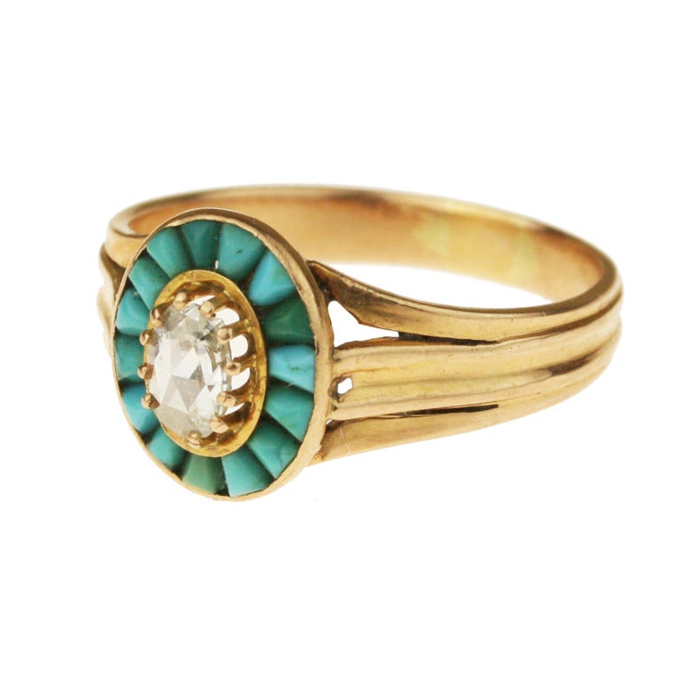 - Victorian Turquoise and Diamond Halo Ring
- c. 1885
- 18k yellow gold with a subtle rose cast, 15 tapered sugarloaf cabochon Persian turquoise, one .14 carat rose-cut diamond (faces up as a .40 carat diamond, as rose cut stones are flat