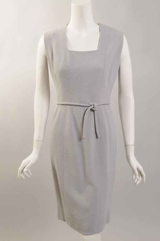 This classic and chic pale grey/blue wool sheath from Pierre Balmain was designed by Osacr de la Renta during his tenure as head designer at the House of Balmain. A nubby wool is used for the low neck, sleeveless sheath with a self belt. The dress