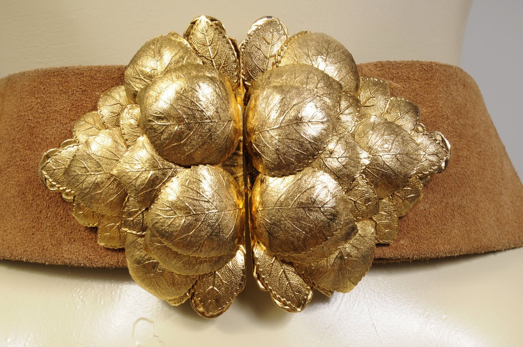 A cluster of three dimensional golden leaves creates a striking two piece belt buckle. The belt is a camel/tan colored suede from Christian Dior for Bonwit Teller. It is adjustable and currently fits a 27