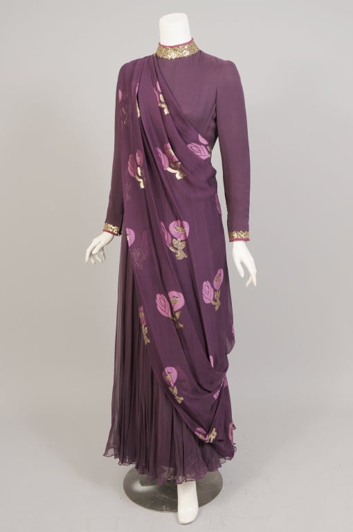 Aubegine silk chiffon is used for this stunning Indian Sari inspired gown designed by Coty Award Winner George Halley in the 1970's. The dress has a round neckline trimmed with tiny gold sequins and rose colored caviar beads. The long sleeves are