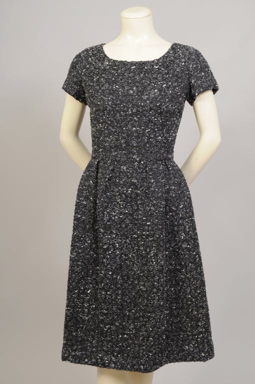 A classic late 1950's day dress by Nina Ricci is elegant enough to go to cocktails and dinner as well. Retailed by Holt Renfrew it is made from a timeless black and white wool tweed. The dress has a scoop neckline, cap sleeves and a fitted