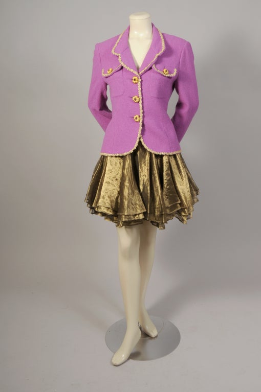 The proceeds from the sale of this charming Lolita Lempicka suit will be donated to Animal Rescue. The suit has an orchid wool jacket trimmed with gold French ribbon and purple 