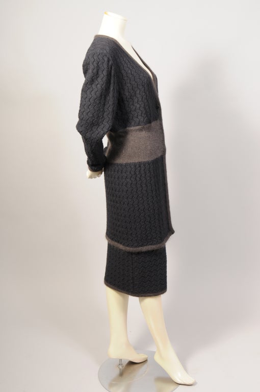 A chic Missoni sweater and skirt outfit is knit from black Alpaca yarn in a signature Missoni pattern. It is accented by a natural grey/beige Alpaca waistband on the sweater and skirt as well as the edges of both garments. The long sweater buttons