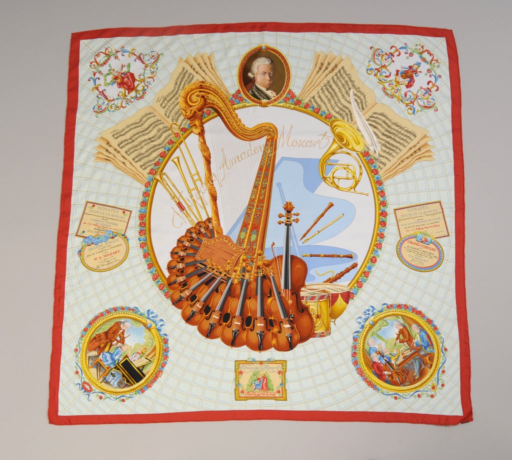 A stunning tribute to Amadeus Mozart by Hermes this scarf is done in shades of light blue with brown, gold and rust accents. It is from the estate of Lyn Revson, a member of the International Best Dressed List. It is in excellent