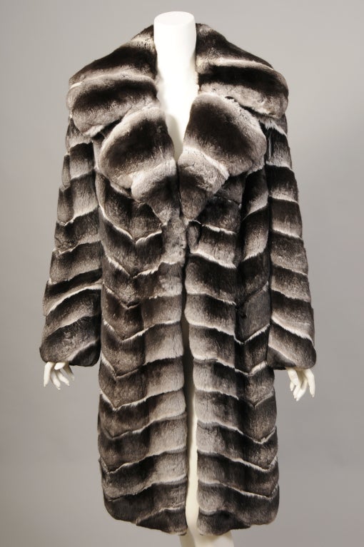 An absolutely stunning Chinchilla coat from Ben Kahn furs is in pristine condition. The pelts are soft and lustrous, worked in a diagonal pattern for a striking look. The coat has a notched collar and there are no closures. The classic styling of