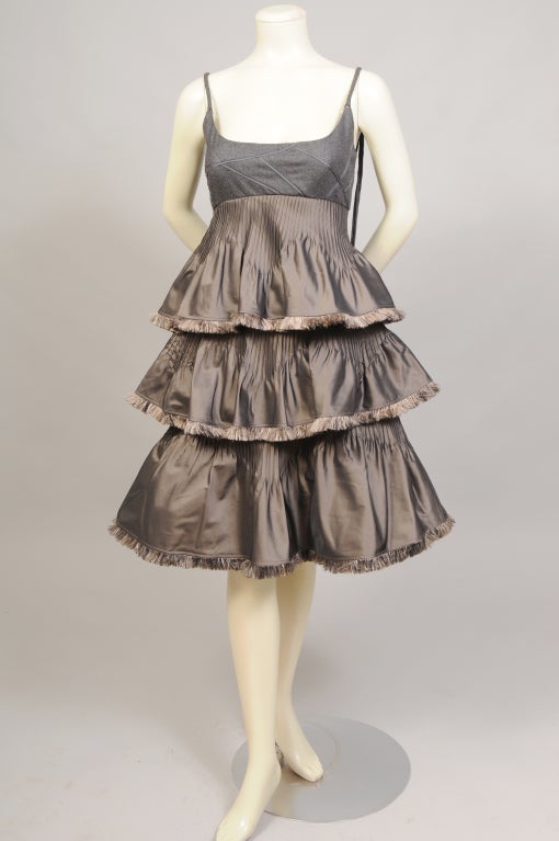 Ralph Rucci has created the most intricate and detailed cocktail dress. The bodice is made from grey flannel with narrow grey ribbon insertion. The grey flannel straps are braided and have streamers down the back of the dress. Three tiers of