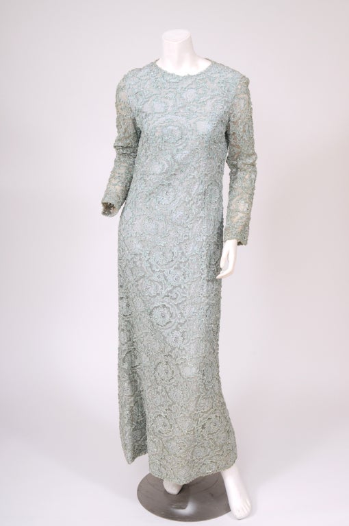 Pale aqua blue lace is re-embroidered with a matching sparkling blue chenille. The rich embellishment plays well against the  spare lines of this 1960's sheath. The body of the dress is fully lined in pale blue silk crepe and the sleeves are lined