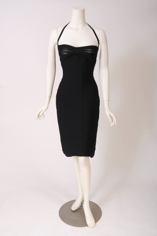 This early bandage dress from Herve Leger has a halter neckline and a semi sheer bandage bustline. Ruching on both sides of the dress is also semi sheer.  The dress is in excellent condition and it is marked a French 3 or an American large.