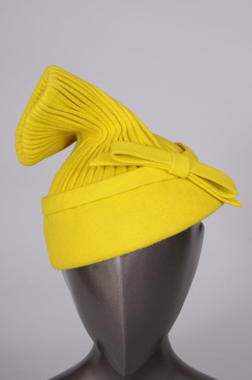 Lemon yellow wool is finely pleated and twisted into a fantastic cocktail hat from Hattie Carnegie. Designed in the 1940's this hat is in pristine condition.

Measurements;
Interior circumference 22