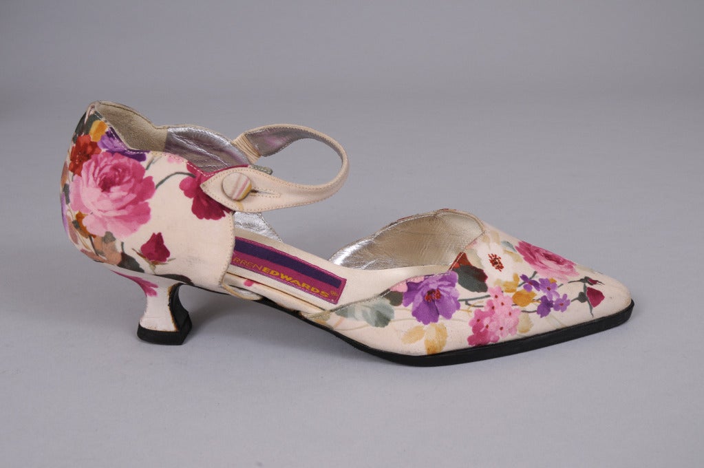 Creamy silk faille printed with blossoms in shades of pink, white, rose, red, lavender and gold covers this ankle strap, kitten heel pump from Susan Bennis warren Edwards.
Never worn, the shoes are lined in cream suede and silver kidskin. They are