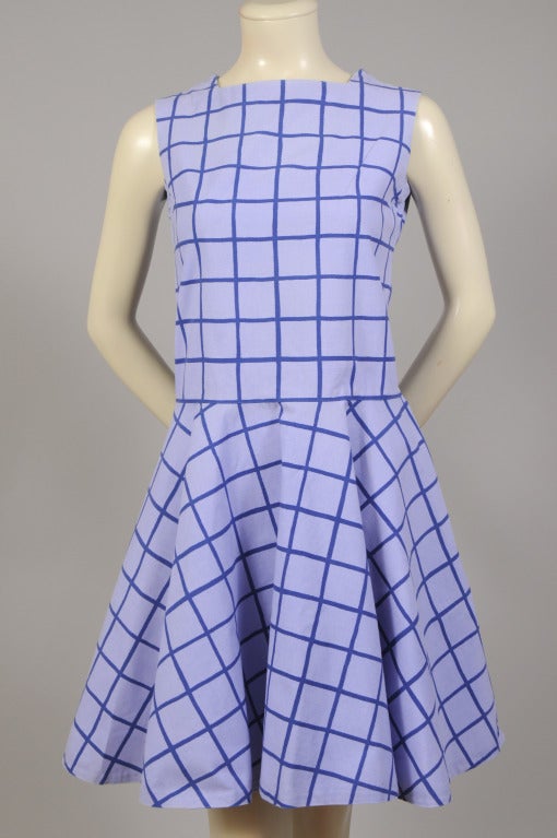 This flirty Marimekko cotton dress is done in the Kukka pattern in two shades of blue. The sleeveless dress has a dropped waist and a full skirt. There are snaps on each shoulder seam and the dress slips on over your head. It is marked a vintage