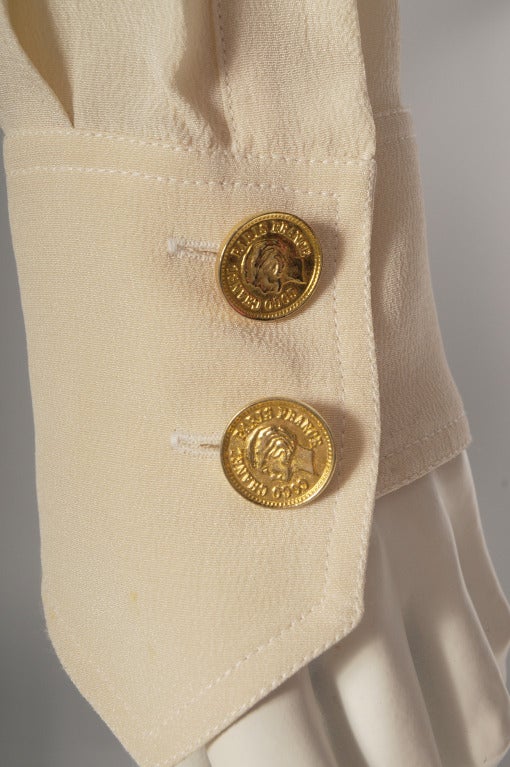 A notched collar, double breasted Eisenhower style jacket has a fitted waistband, a pleated back and long sleeves with pointed cuffs. Chanel gold toned portrait buttons enhance the look. This jacket is in excellent condition. 

Measurements;