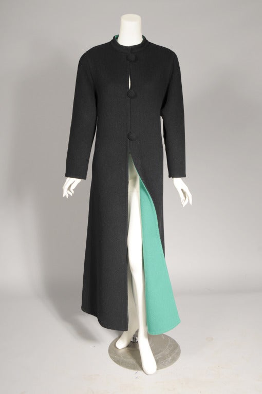 An edgy combination of a sleek and classic black coat that reverses to a bright green is quite versatile. The collarless coat has three large black buttons and loops at the center front. It is in excellent condition.
Measurements;
Shoulders