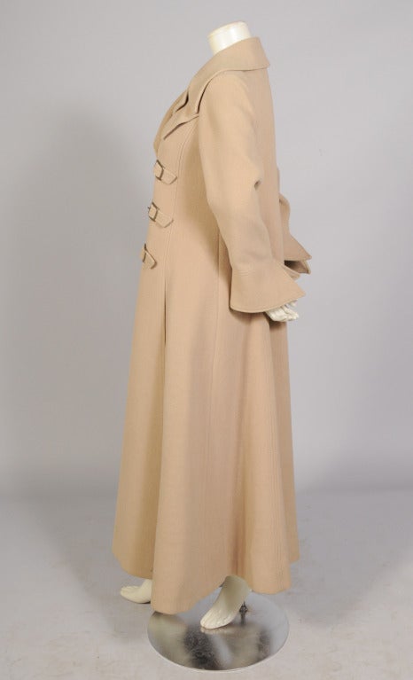 This camel hair maxi coat has tremendous styles with a large notched collar, three buckle closure to the left of center and stylish flared cuffs. Two pockets are concealed in the side seams and the coat is fully lined. It is in excellent