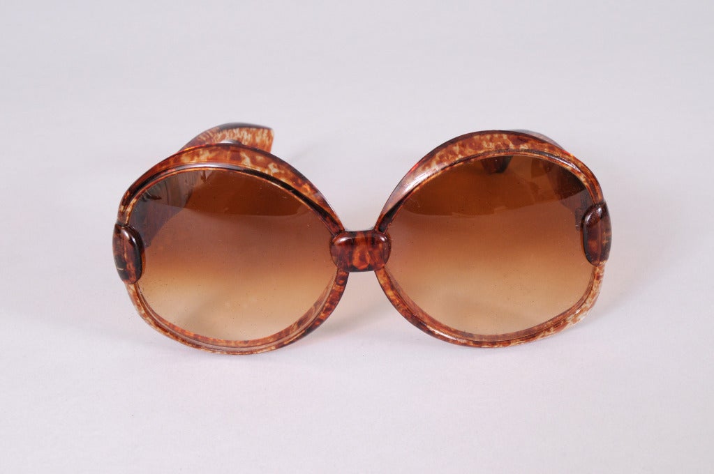 Oversized 1970's sunglasses with gradient lenses are framed in tortoise shell with the YSL logo on the side. They are in excellent condition.