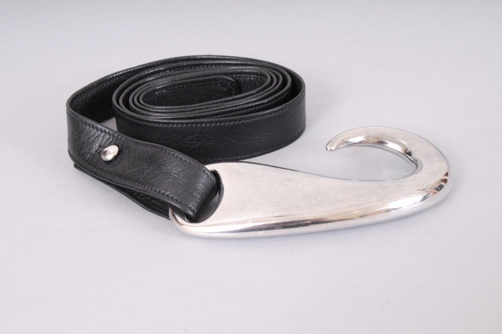 A sterling silver buckle, inspired by a fish hook, is attached to a supple black leather belt. Both pieces are marked Tiffany & Co. and they are in excellent condition.

Measurements;
Buckle 
Length 4 1/2