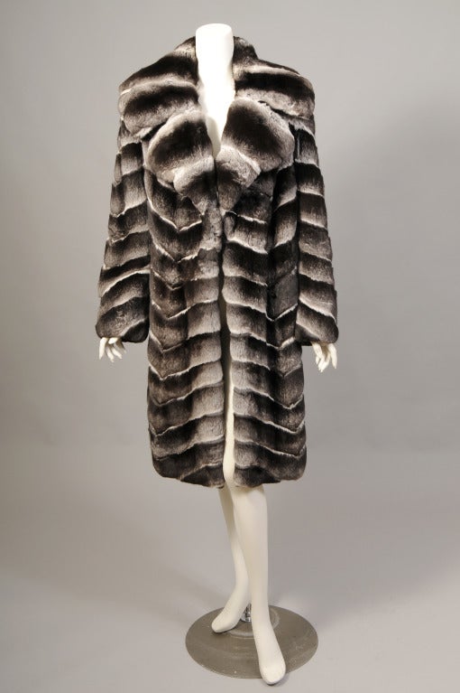 An absolutely stunning Chinchilla coat from Ben Kahn furs is in pristine condition. The pelts are ultra soft and lustrous, worked in a diagonal pattern for a striking look. The coat has a notched collar and there are no closures. The classic styling