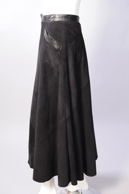 Supple black suede, cut and pieced on the bias, is accented with black leather at the waist and pocket. The skirt has a center back zipper and two snaps. It is fully lined and in excellent condition.

Measurements;
Waist 27