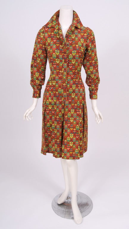 A cheerful and colorful print enlivens this 1970's light weight wool dress from YSL. The dress has a button front, long sleeves with button cuffs, and stitched down box pleats in the skirt. It is in excellent condition and marked a vintage size