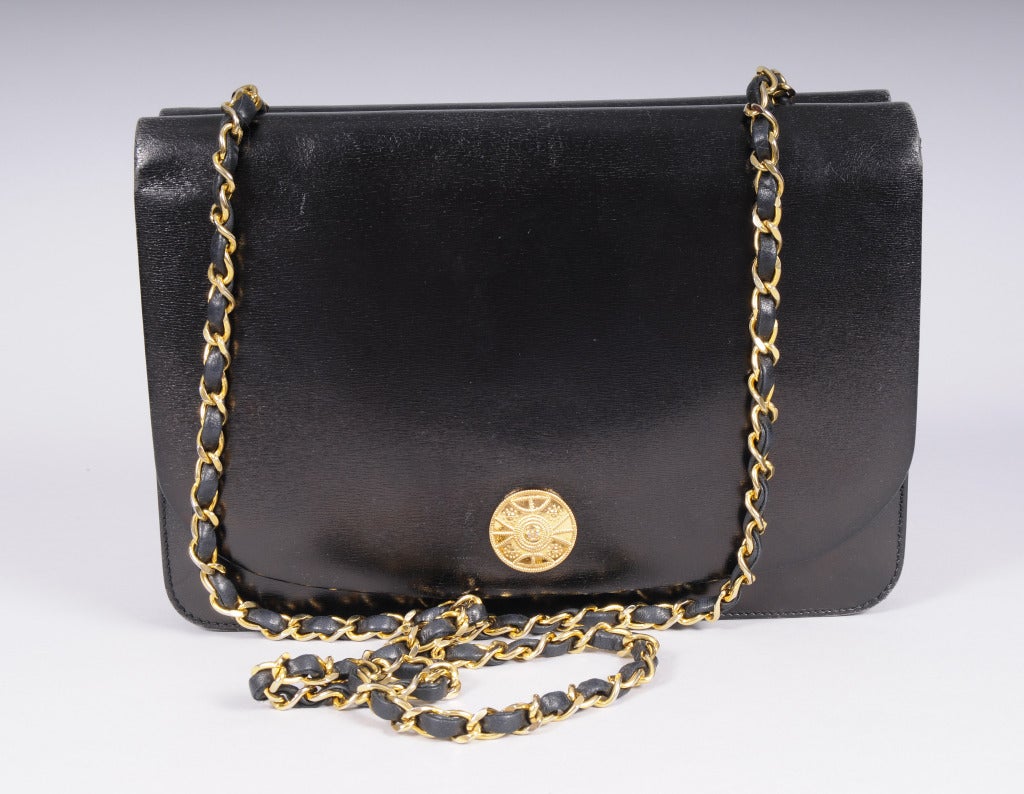 Classic black leather is accented  with a gorgeous golden double C Chanel medallion on each side of this double sided bag with a leather laced chain strap in the center, an elegant example from Chanel. The bag is lined in burgundy lambskin with a