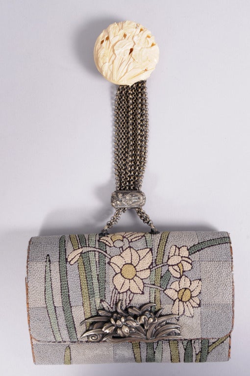 From a Beverly Hills collector, this stunning 19th century Japanese tobacco pouch makes a wonderful evening bag. It is hand embroidered with a floral design set against a grey checker board background. A silver floral clasp decorates the front and a