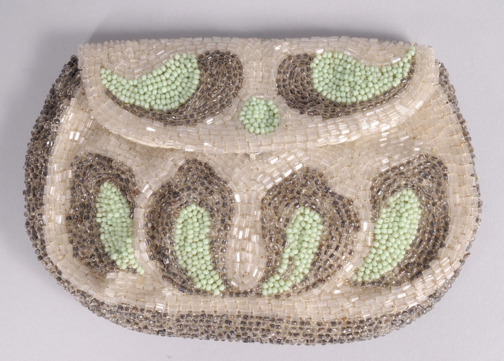 From a Beverly Hills collector, this bag was Made in France in the 1920's and it has crystal bugle beads and boteh shaped designs made form silver and green bugle beads. The sides and bottom of the bag are made from silver caviar beads. The snap