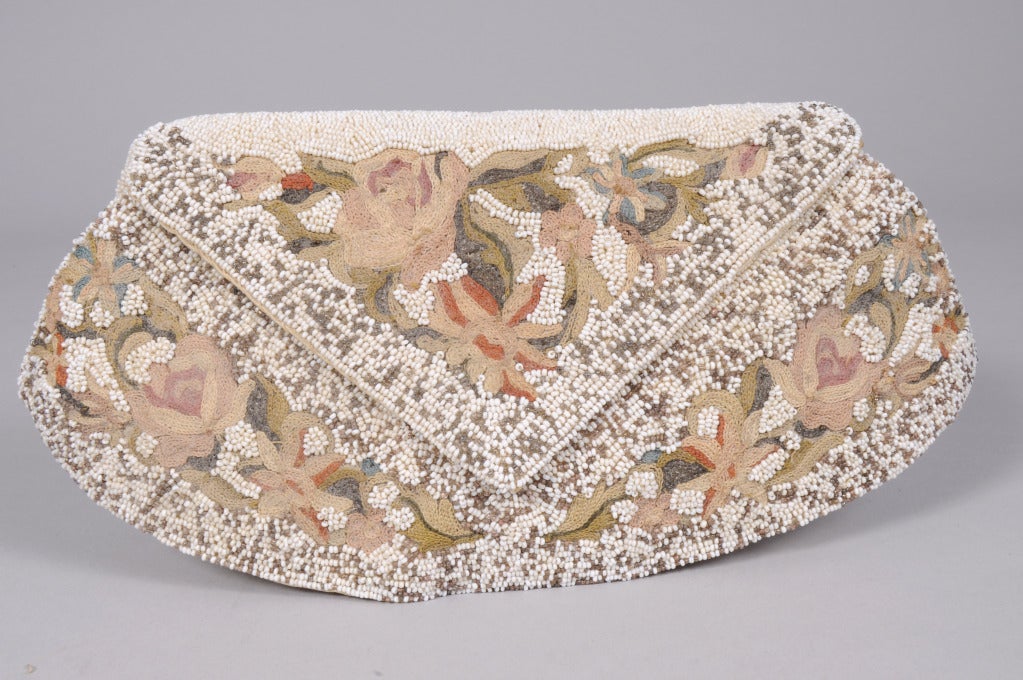 From a Beverly Hills collector, colorful floral embroidery and beige and white caviar beads decorate the front of this white caviar beaded bag, Made in France in the 1930's. The back of the bag has a beaded strap and two more floral motifs. The